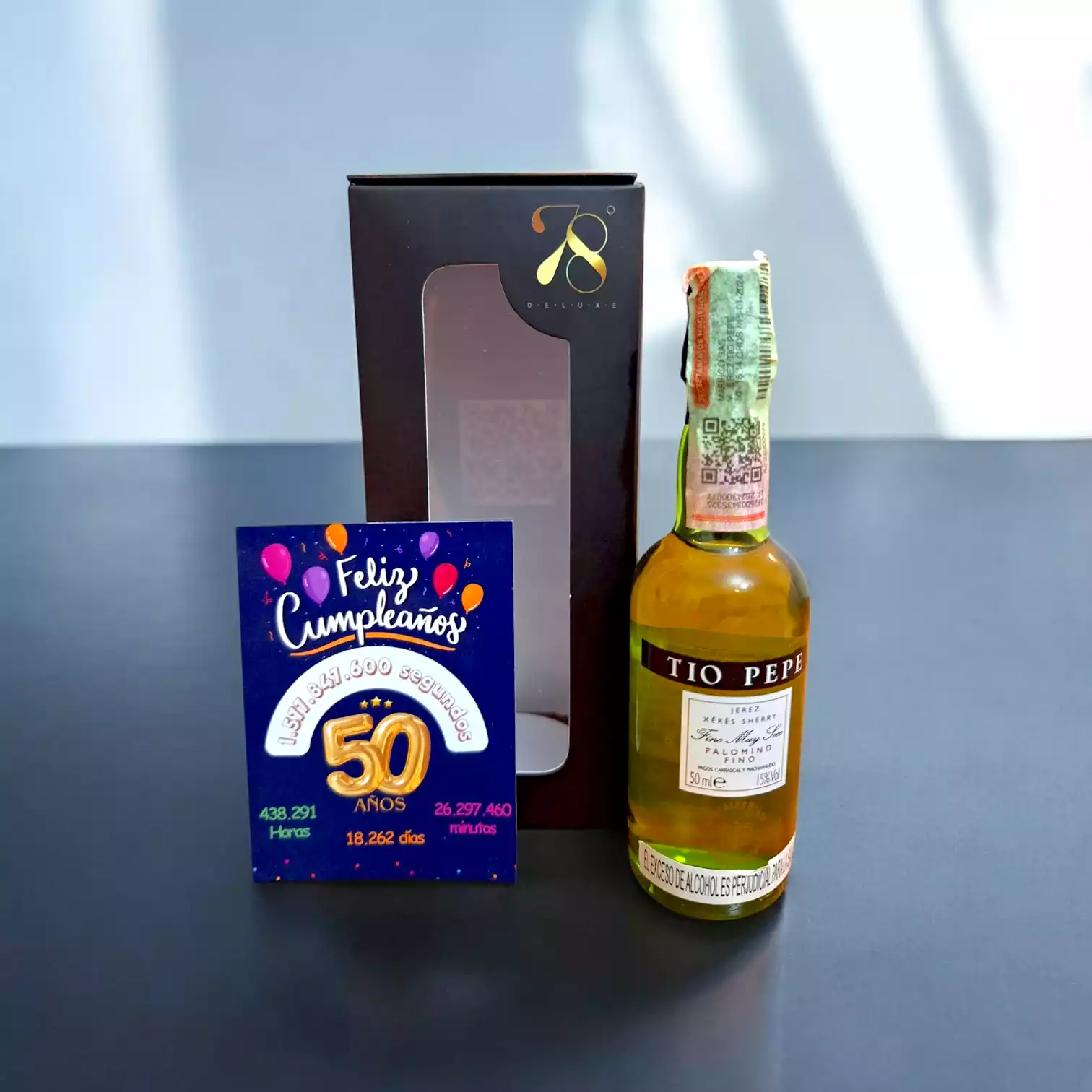 La Mini Botella de Jerez Tío Pepe 50ml es una versión compacta de uno de los vinos de Jerez más icónicos del mundo. Producido en España por la prestigiosa bodega González Byass, este fino es reconocido por su frescura, elegancia y carácter seco. Su crianza bajo el tradicional velo de flor en barricas de roble americano le otorga un perfil único, convirtiéndolo en el acompañante ideal para tapas y mariscos. En 78 Grados Deluxe, esta mini botella se entrega en una caja premium individual con una tarjeta impresa personalizada, ofreciendo una presentación sofisticada y exclusiva, perfecta para regalar en cualquier ocasión. La Mini Botella de Jerez Tío Pepe 50ml es una versión compacta de uno de los vinos de Jerez más icónicos del mundo. Producido en España por la prestigiosa bodega González Byass, este fino es reconocido por su frescura, elegancia y carácter seco. Su crianza bajo el tradicional velo de flor en barricas de roble americano le otorga un perfil único, convirtiéndolo en el acompañante ideal para tapas y mariscos. En 78 Grados Deluxe, esta mini botella se entrega en una caja premium individual con una tarjeta impresa personalizada, ofreciendo una presentación sofisticada y exclusiva, perfecta para regalar en cualquier ocasión.