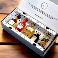 Caja de regalo con mini botellas importadas: whisky, cognac, licor y aperitivo. Presentación de lujo y tarjeta personalizada. Un regalo premium y memorable – 78 Grados Deluxe