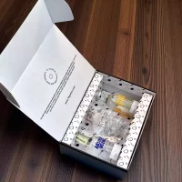Caja premium de vodkas en mini botellas: Crystal Head, Absolut Original y Absolut Mandarin. Incluye tarjeta – Caja personalizada con nombres y logos – 78 Grados Deluxe