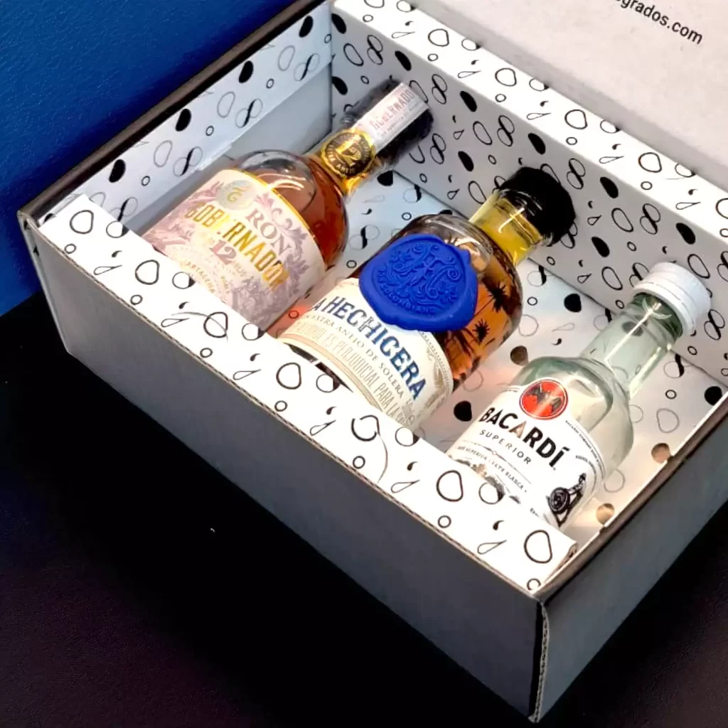 Estuche premium con mini botellas de ron: La Hechicera, Gobernador 12 años y Bacardí. Incluye tarjeta personalizada y opción de nombre en vinilo - 78 Grados Deluxe